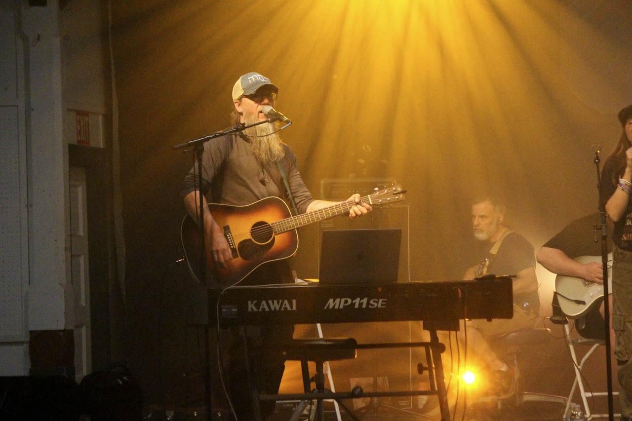 After Sunday musician singing while playing guitar and keys